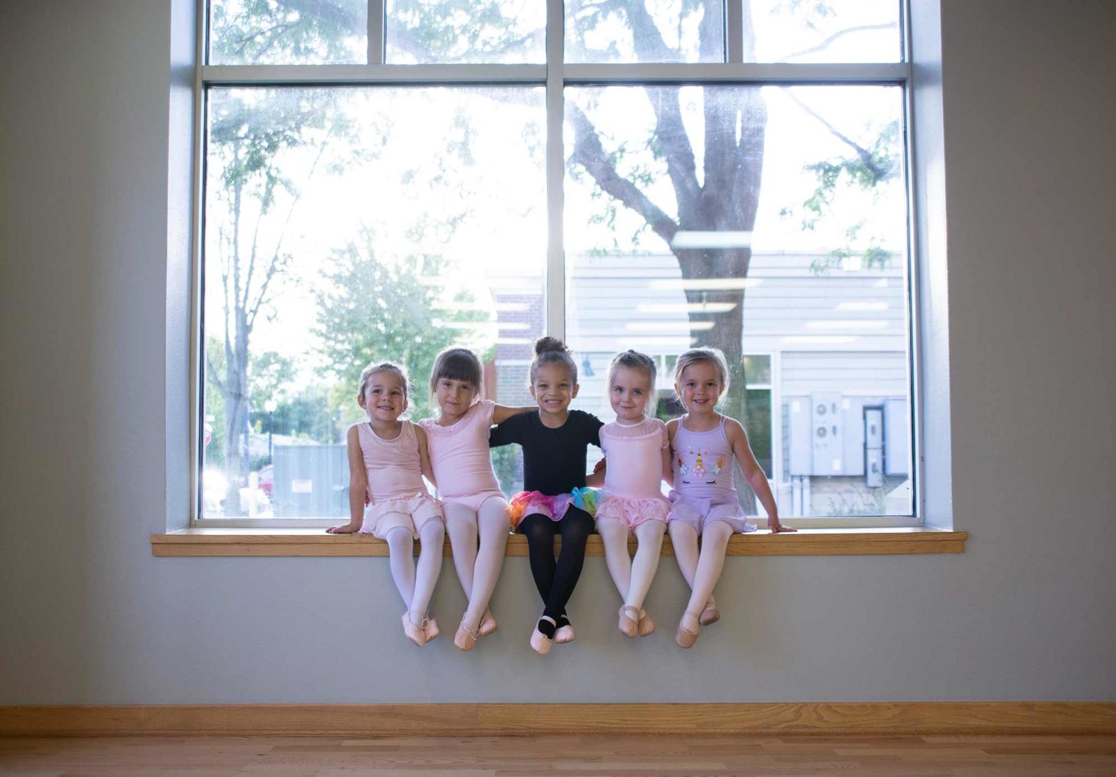 Young dancers sitting on a window ledge
